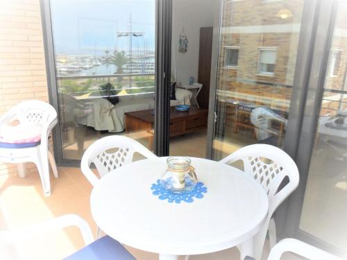 een witte tafel en stoelen in een kamer met een raam bij Apartment La Platja by Interhome in L'Estartit