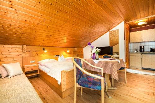 a bedroom with a bed and a table and a kitchen at Genusshotel Hohenbogen GARNI in Neukirchen beim Heiligen Blut