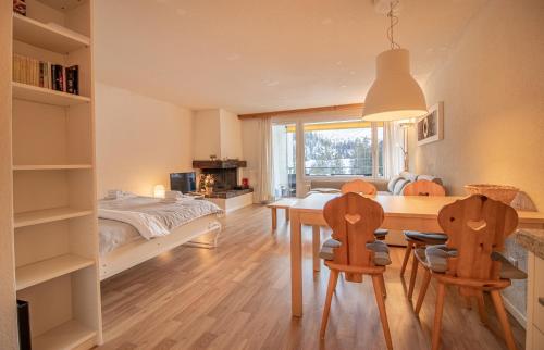 een slaapkamer met een tafel en stoelen en een bed bij Rothornblick 57 by Arosa Holiday in Arosa