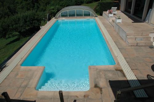 an overhead view of a swimming pool with blue water at Chalets du Vieux Frêne in Saint-Hilaire