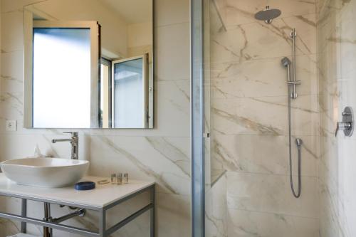 La salle de bains est pourvue d'un lavabo et d'une douche. dans l'établissement Mercury Rooms, à Cagliari