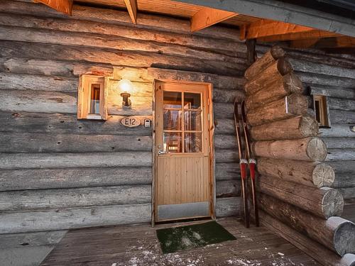 eine Holzhütte mit einer Tür und einem Fenster in der Unterkunft Holiday Home Ylläsniesta 5 e 12 by Interhome in Äkäslompolo