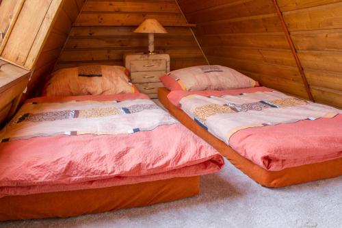 two twin beds in a room with a attic at Chata u lesa in Prostřední Bečva