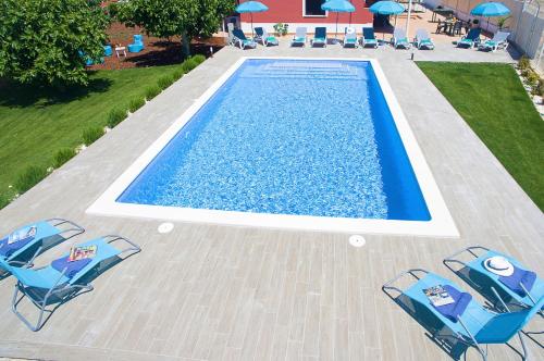 una vista aérea de una piscina con sillas y sombrillas en Villa Zanzibar by Algarve Vacation, en Olhos de Água