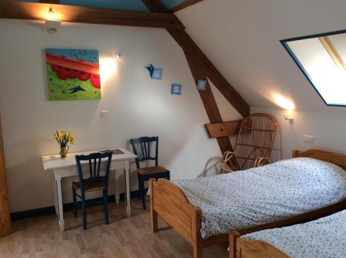 um quarto com uma cama, uma mesa e cadeiras em La Cense des 6 Sens em Beugny