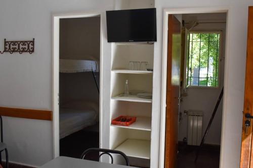 a room with a closet with a tv and a bedroom at Ruca Hue in Puerto Madryn