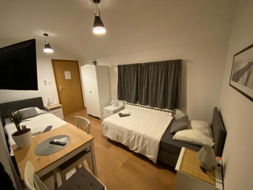 a hotel room with two beds and a table and a desk at Guest House Lucija in Zagreb