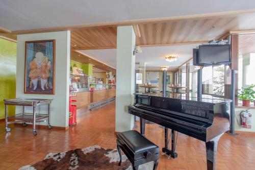 a living room with a piano and a tv at TOP Appartamenti in Passo del Tonale