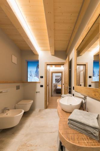 a bathroom with two sinks and two toilets at Latemar Fiemme Apartments in Tesero