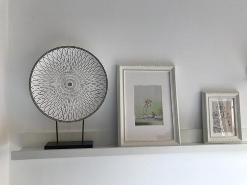 a shelf with three pictures and a fan on it at Holiday in Playa Calera - Swimming pool in Valle Gran Rey