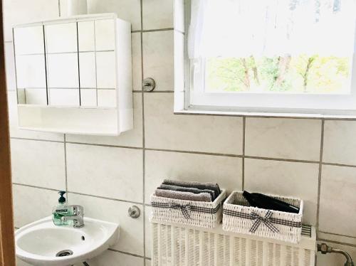 a bathroom with a sink and a mirror and towel baskets at No2 TOP Apartment4YOU - 3 Zimmer, 1-6 Pers, Saarbrücken - Jägersfreude Saarbruecken in Saarbrücken