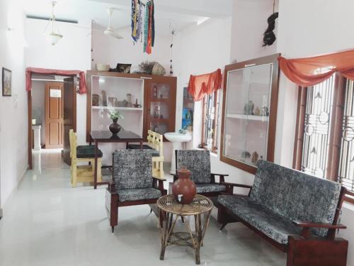 a living room with couches and chairs and a table at Varkala Days Home Stay in Varkala