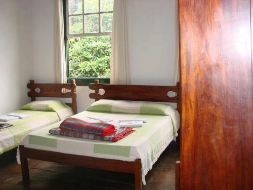 two twin beds in a room with a window at Hotel Pousada Hospedaria Antiga in Ouro Preto