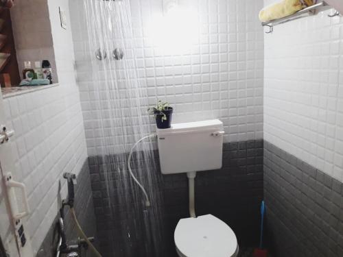 a bathroom with a toilet with a light above it at Varkala Days Home Stay in Varkala