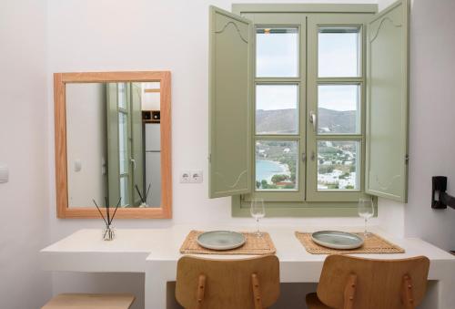 un bagno con due specchi, un lavandino e due sedie di Theasis Suites ad Amorgo