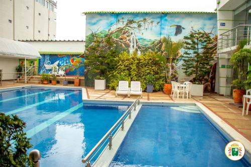 una piscina con un mural en el lateral de un edificio en Hotel Caquetá Real HSC, en Florencia