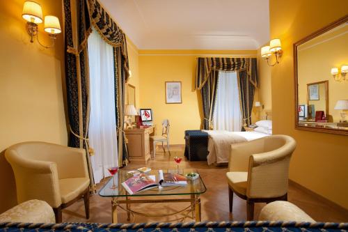 a hotel room with a bed and a table and chairs at Imperial Hotel Tramontano in Sorrento