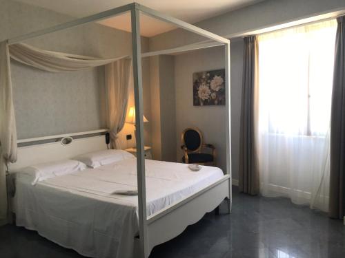 a bedroom with a canopy bed and a window at Marina Holiday & Spa in Balestrate