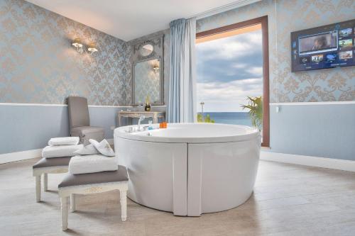 a bathroom with a tub and a large window at Marina Holiday & Spa in Balestrate