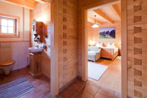 ein Badezimmer mit WC und ein Wohnzimmer in der Unterkunft Chaletwohnung Lederer in Ebbs