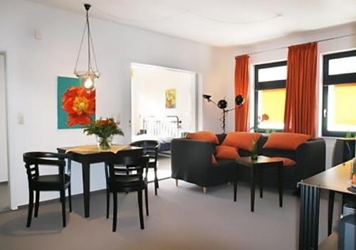 - un salon avec un canapé, une table et des chaises dans l'établissement Ferienwohnung KLÜN's, à Jever