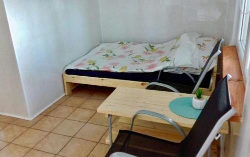 a small room with a bed and a table and a desk at Łabędź I Domki nad jeziorem in Rajgród