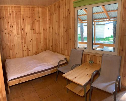 una camera con un letto e due sedie e un tavolo di Domki Nad Jeziorem I Łabędź a Rajgród