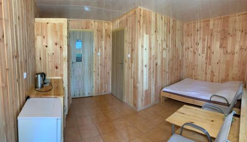 a small room with a bed and a table at Łabędź I Domki nad jeziorem in Rajgród