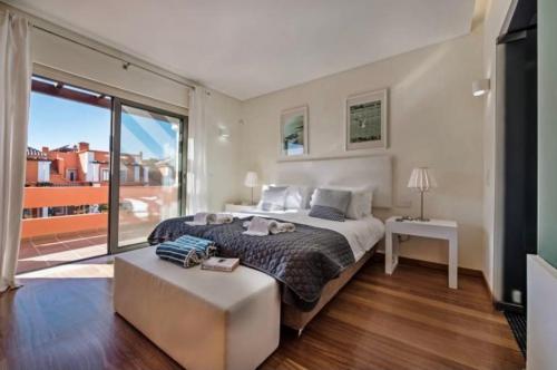 een slaapkamer met een groot bed en een groot raam bij Villa Lux - 5O in Luz de Tavira