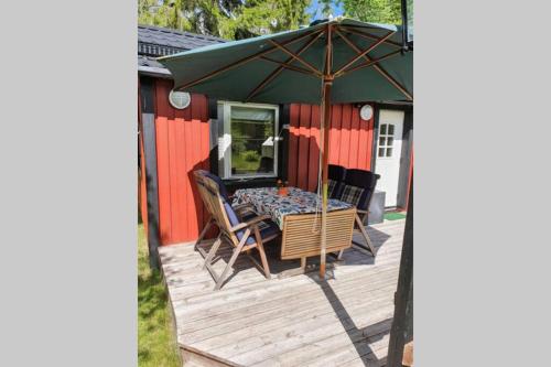 a patio with a table and an umbrella at Guesthouse at Ingarö Stockholm archipelago (breakfast) in Grönskan
