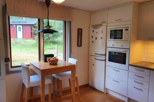 a kitchen with a table and a white refrigerator at Guesthouse at Ingarö Stockholm archipelago (breakfast) in Grönskan