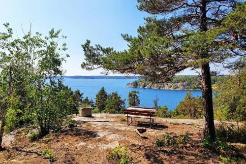 a bench sitting on top of a hill next to a lake at Guesthouse at Ingarö Stockholm archipelago (breakfast) in Grönskan