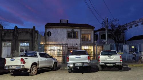 tres camiones estacionados frente a una casa en Pousada Corumba Center, en Corumbá