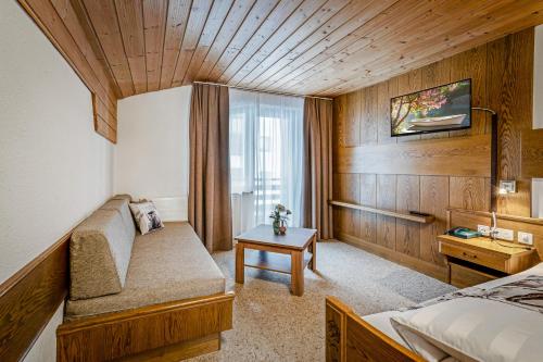a hotel room with a couch and a window at Haus Derby in Samnaun