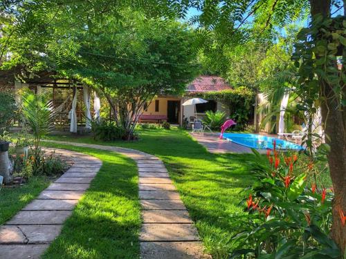 a garden with a pathway leading to a swimming pool at Casa de Férias em Alter do Chão-PA in Alter do Chao