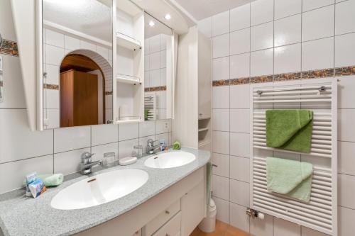 ein Badezimmer mit 2 Waschbecken und einem Spiegel in der Unterkunft Haus Derby in Samnaun