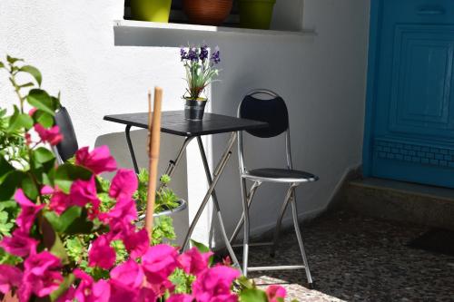 uma mesa preta e cadeiras ao lado de algumas flores cor-de-rosa em Nicola's House with private parking em Kavala