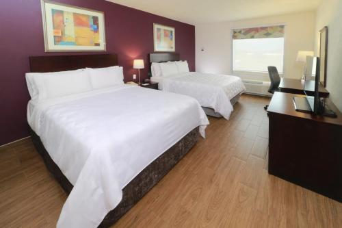 a hotel room with two beds and a television at Holiday Inn Reynosa Industrial Poniente by IHG in Reynosa