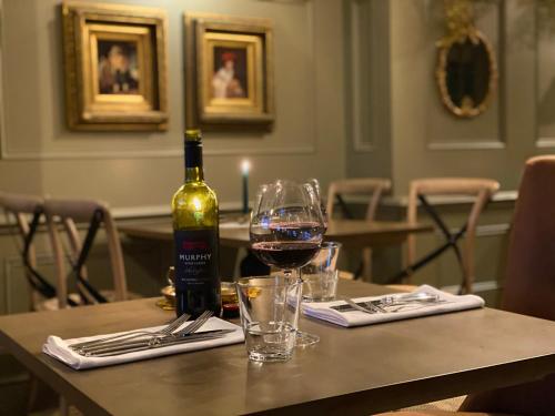 a bottle of wine and a glass on a table at The George Hotel Easingwold in Easingwold