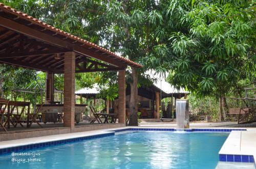 einen Pool mit einer Pergola und Bäumen in der Unterkunft Oca Tocarijus Eco Resort in Piracuruca
