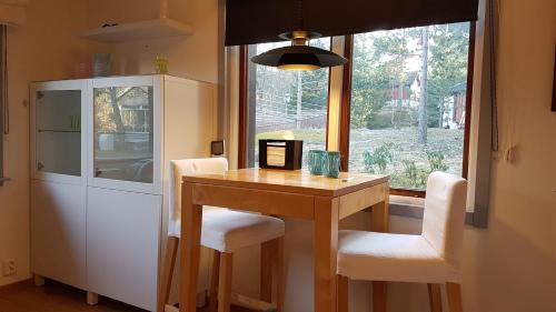 a kitchen with a table and chairs and a window at Guesthouse at Ingarö Stockholm archipelago (breakfast) in Grönskan