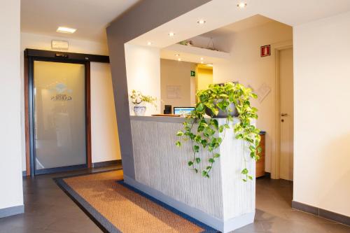 a lobby with a counter with a potted plant at Hotel Garden in Levanto