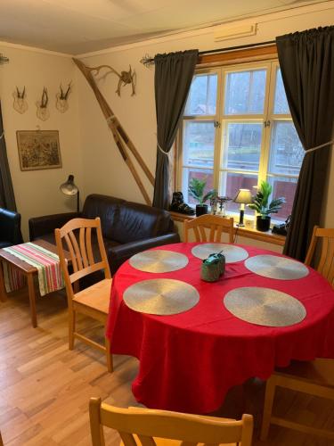 a living room with a red table and chairs at Sea Side Cabin in Borlänge