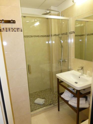 a bathroom with a shower and a sink at Hotel Capitole in Beausoleil