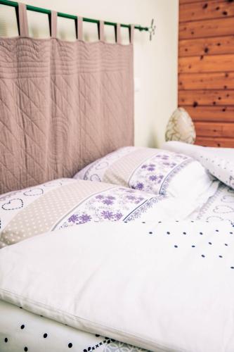 a bed with white sheets and pillows on it at Hôtel Restaurant Domaine De Basil in Orbey