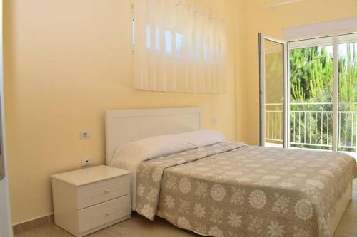 - une chambre avec un lit et une grande fenêtre dans l'établissement Luna`s beachfront apartment in Residence Primavera Lalzit, à Durrës