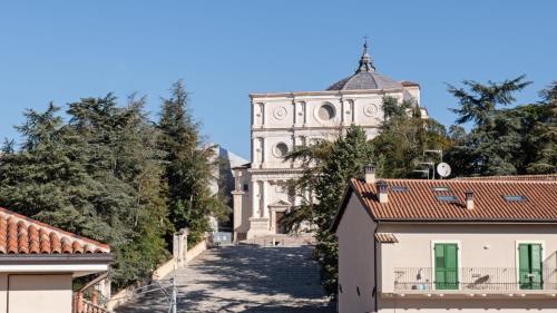 a view of a church from the roofs of houses at Dimora Fortebraccio in LʼAquila