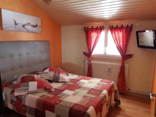 une chambre avec un lit, une télévision et une fenêtre dans l'établissement Gîte Les Glycines, à Gérardmer