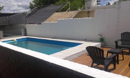 una piscina en una terraza con 2 sillas y una mesa en Doña Aida en Mina Clavero