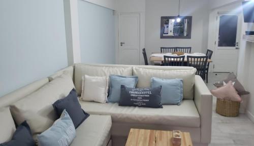 una sala de estar con un sofá blanco con almohadas azules en Euritmia Departamentos de Playa en Villa Gesell